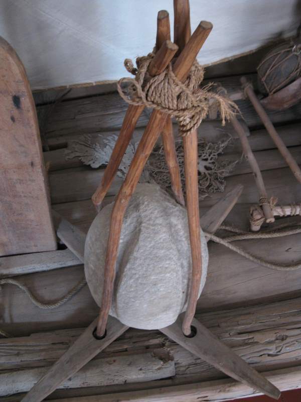 An old stone anchor on the deck of a raft jangada