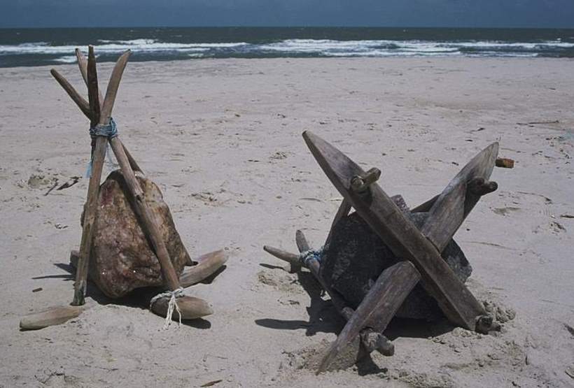 Two fateixas sitting on the sand. One turned over to see its bottom.