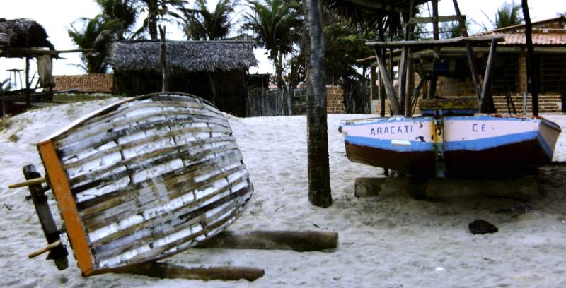Two jangadas on the beach. One of them is made from Styrofoam encased in a wood frame.