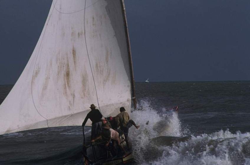 A jangada getting pounded by a crashing wave.