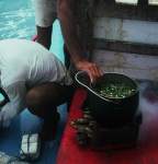 Jangadeiro setting the fish stew pot on the fire.