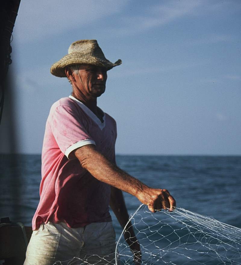 A jangadeiro pulling in a fishing net.