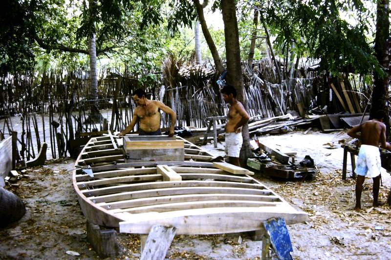 Carpenters working on the hull of a Jangada de Tábuas (planked jangada).