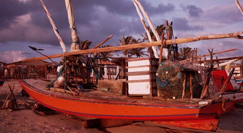 A jangada on the beach with its icebox and fishing nets.