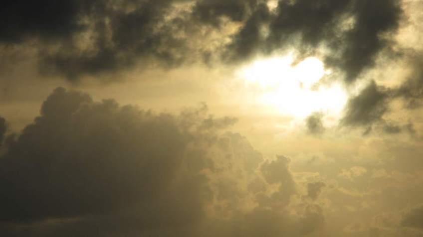 Sky with sun filtering through clouds.