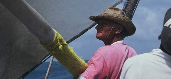 A jangadeiro removing the boom from the mast.